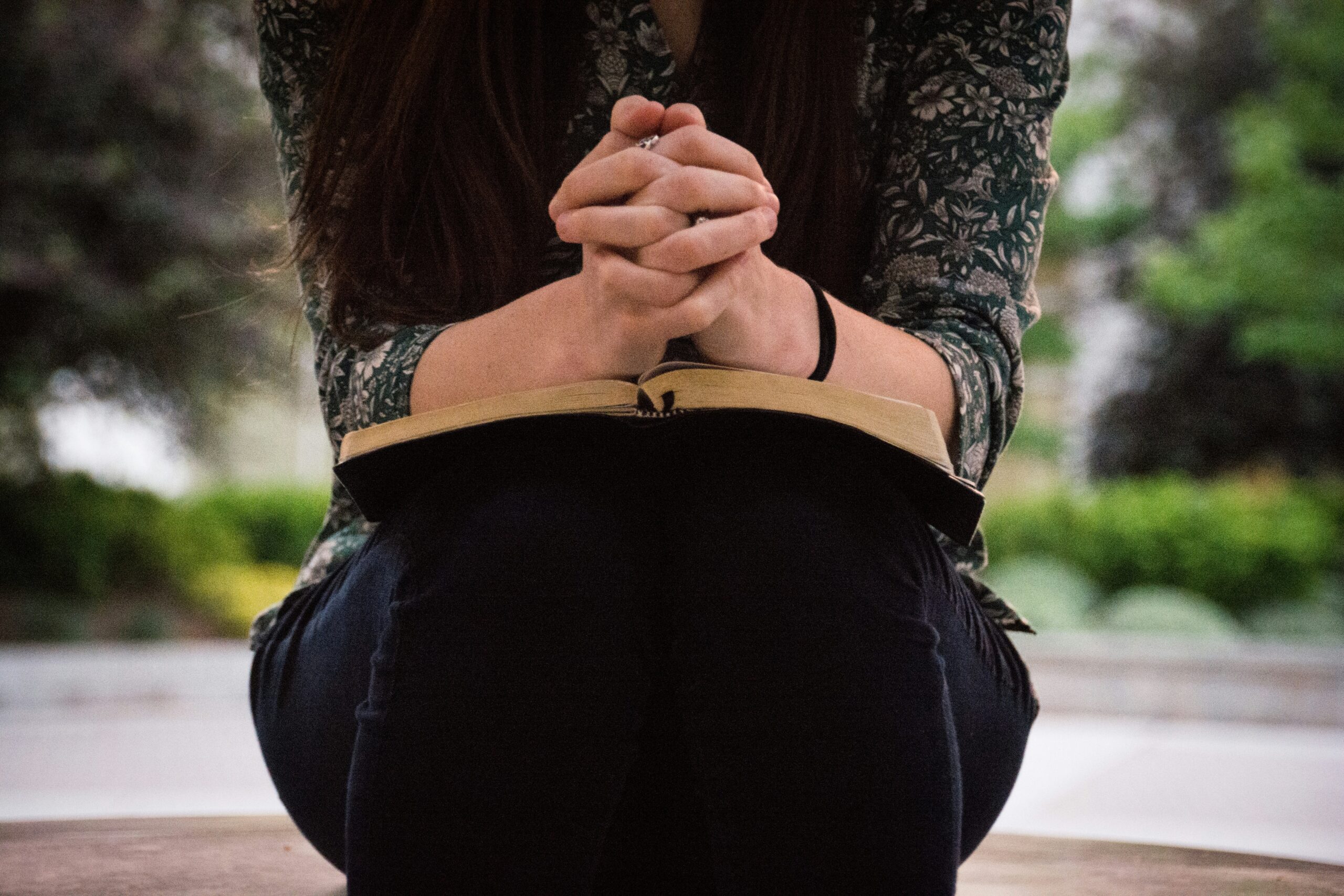 Praying hands on open Bible