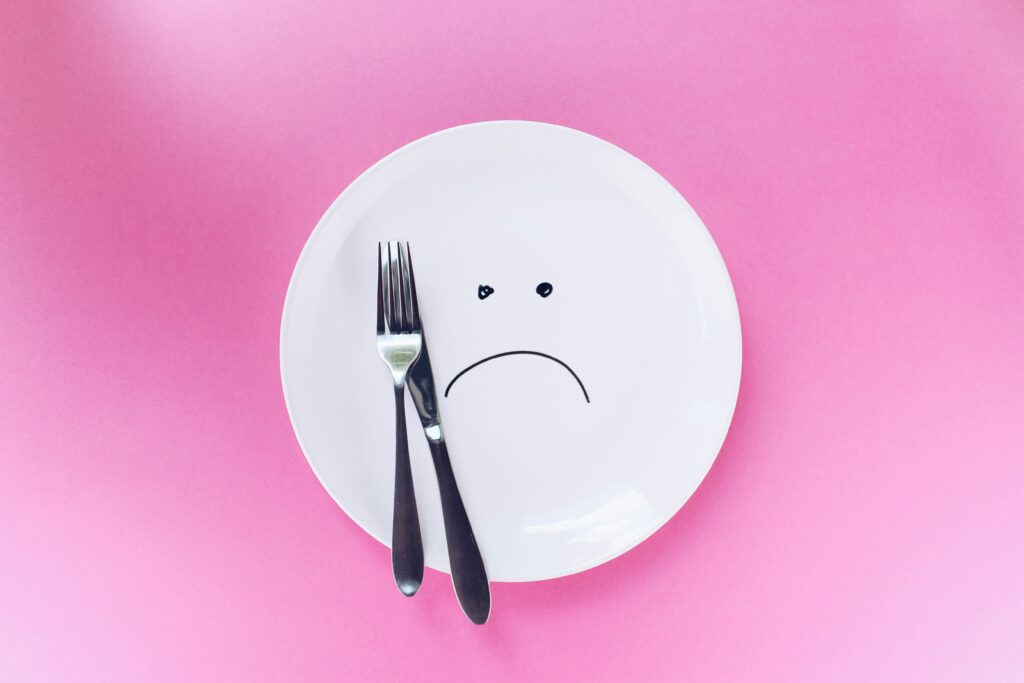 plate with sad face on pink background